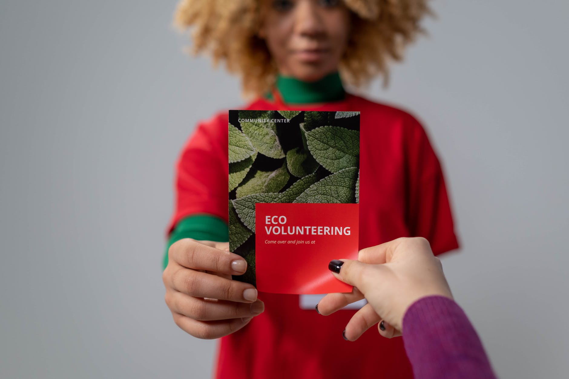 person holding red brochure